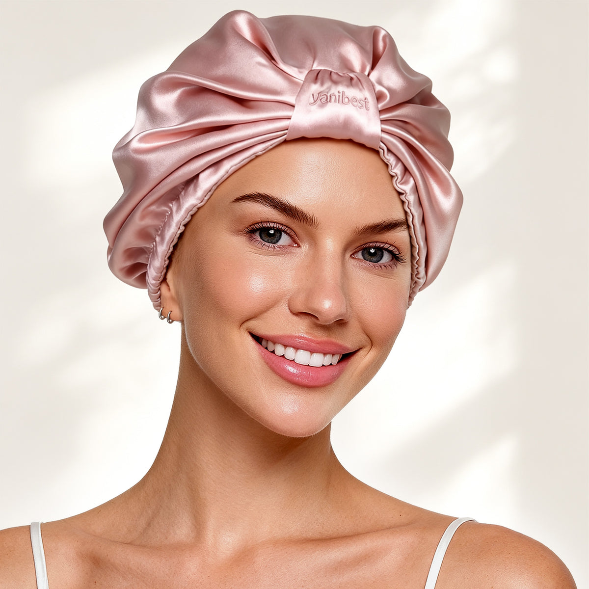 Smiling woman wearing the YANIBEST pink 22 Momme mulberry silk turban bonnet for hair protection