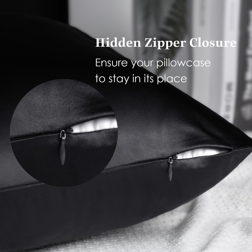 Black silk pillowcase with hidden zipper closure on a bed, close-up detail shown.