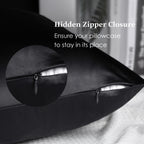 Black silk pillowcase with hidden zipper closure on a bed, close-up detail shown.
