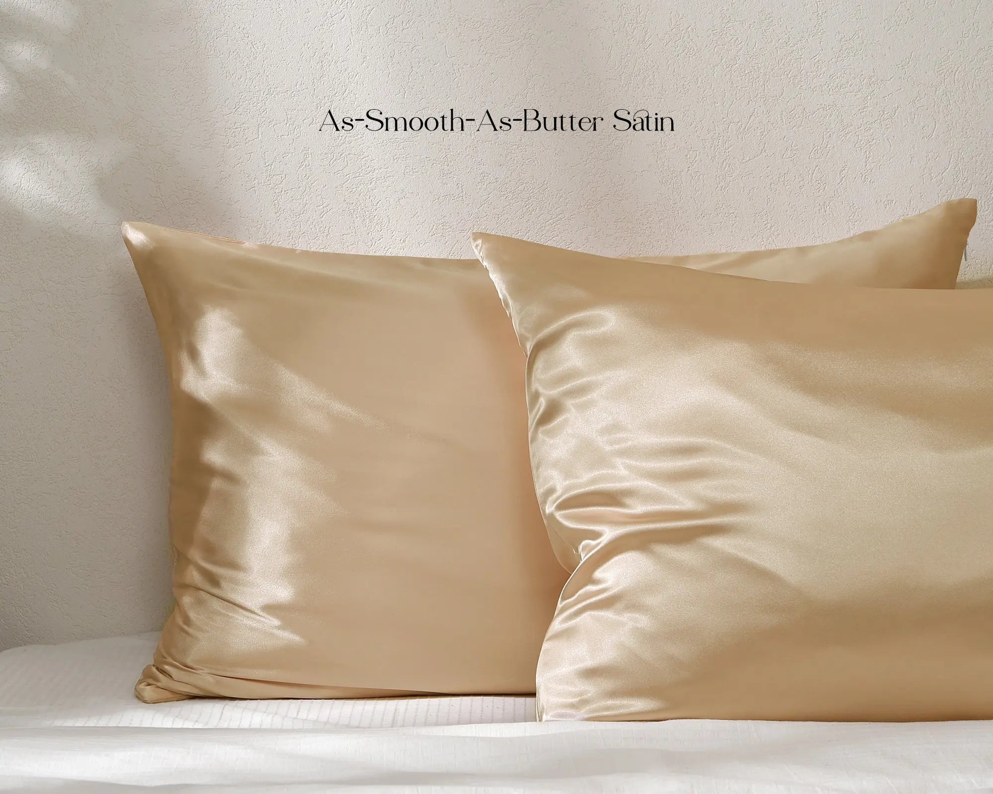 Golden champagne satin pillowcases set on a bed with smooth, shiny finish