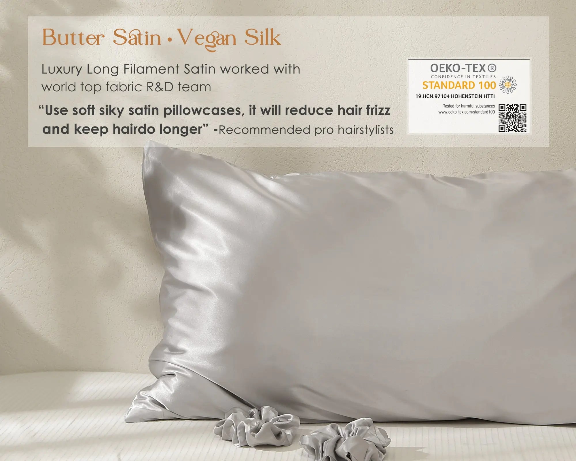 Silver gray satin pillowcase on a bed with matching hair scrunchies, text highlights softness and vegan silk material.