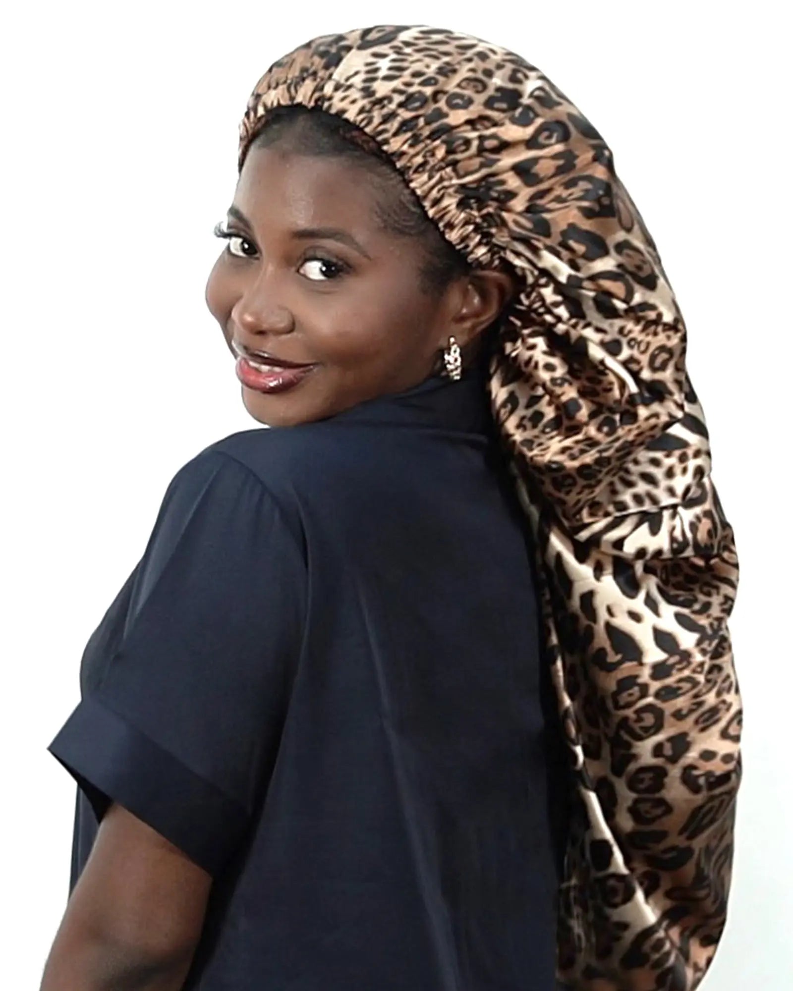 Woman wearing a long tail satin bonnet in leopard print for hair protection