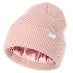 Rose pink satin-lined beanie hat, unisex, soft knit with visible YANIBEST tag and shiny interior.