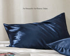 Ocean blue satin pillowcases with smooth shiny finish on a white bed
