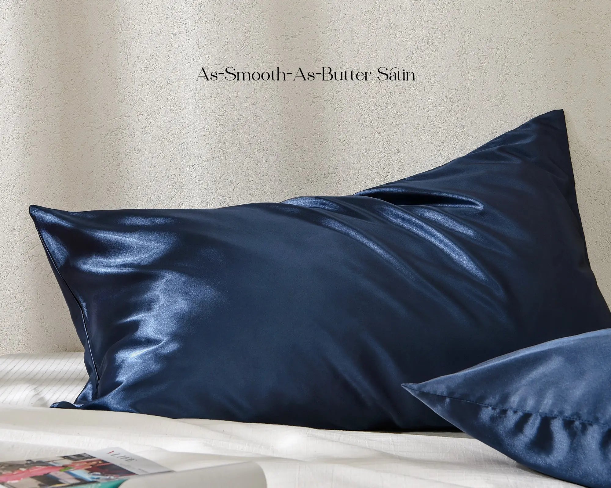 Ocean blue satin pillowcases with smooth shiny finish on a white bed